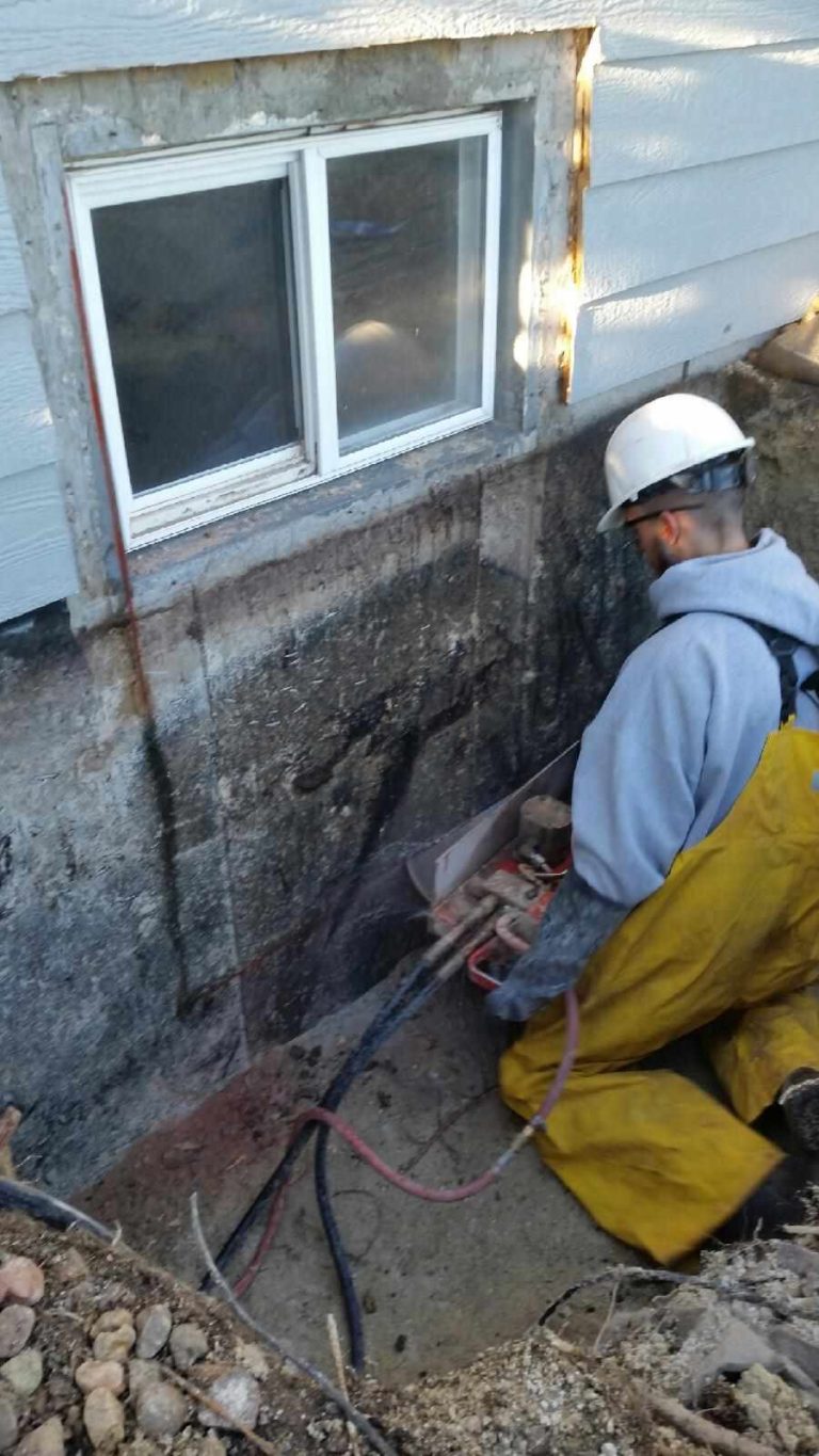 Worker cutting a concrete foundation wall with a wall saw