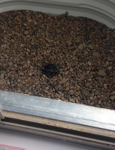 New drain installed at the bottom of a window well