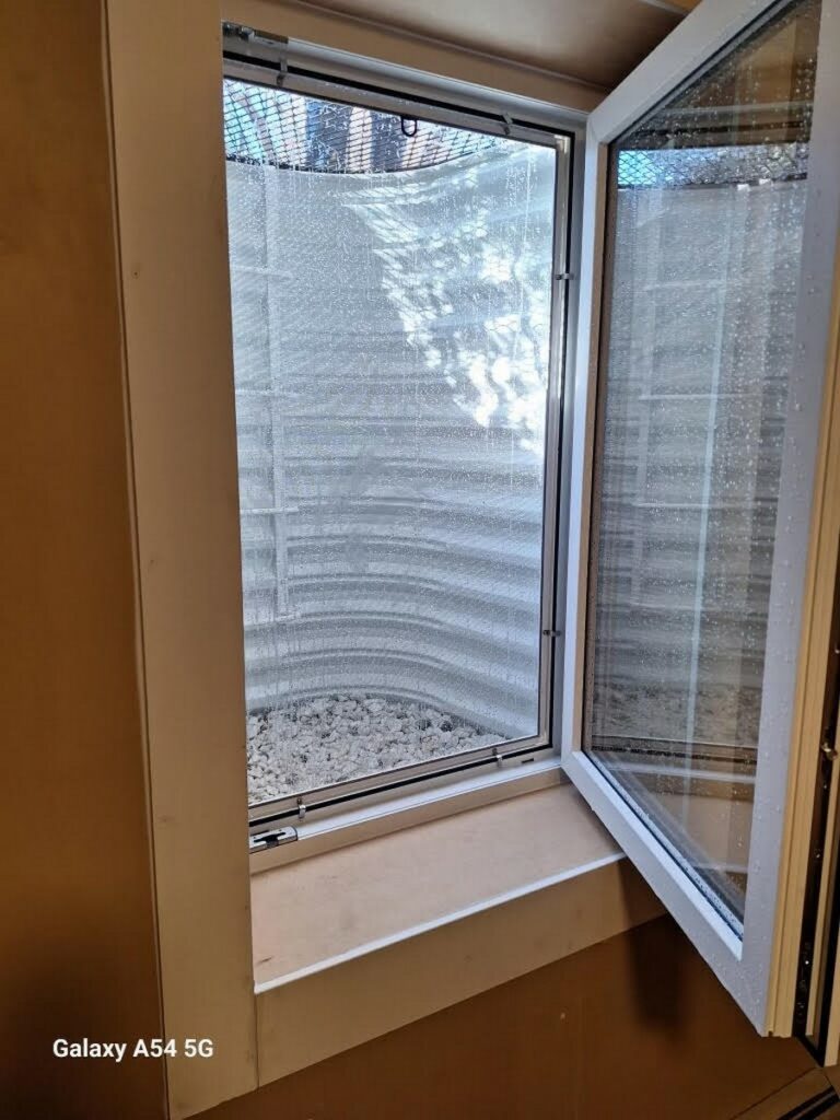 Denver Basement Egress Window Installation with Bronze Grate