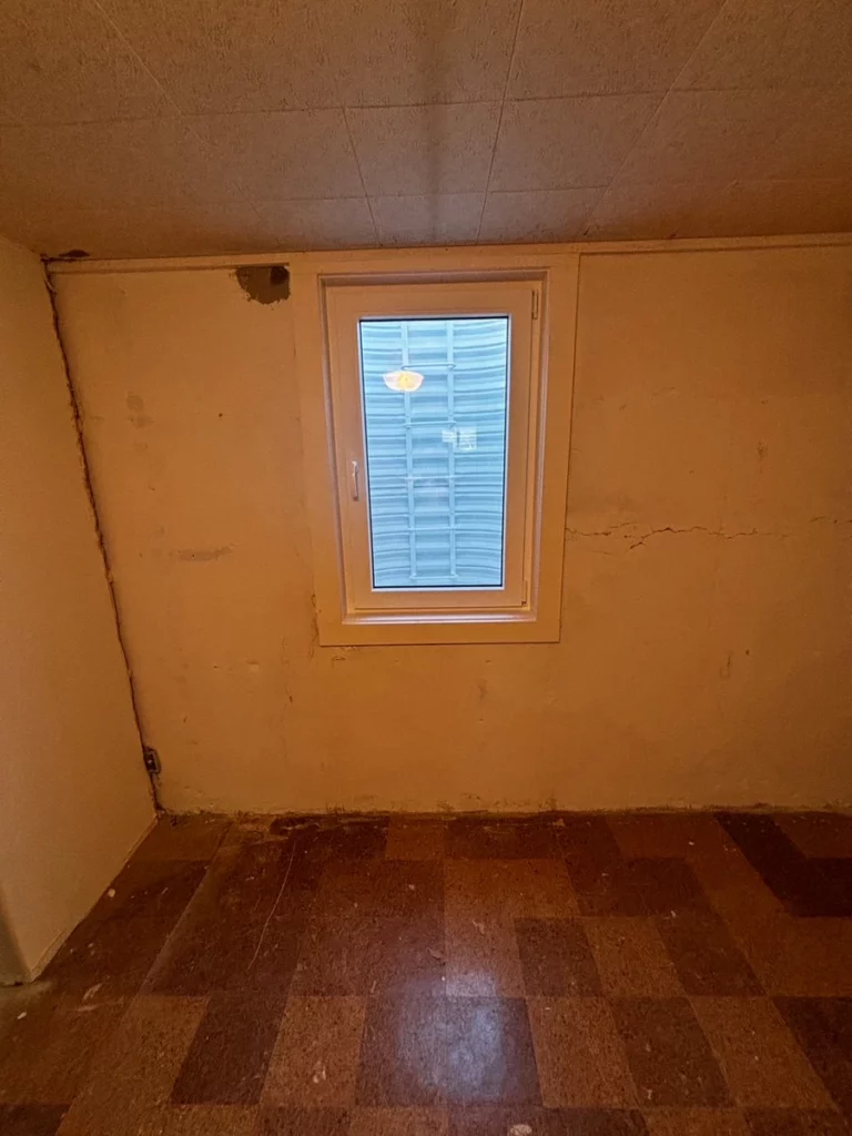 White European tilt and turn window installed in an enlarged basement opening in Boulder, CO.